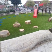 Kunstgras op het schoolplein, met natuurijke speelelementen